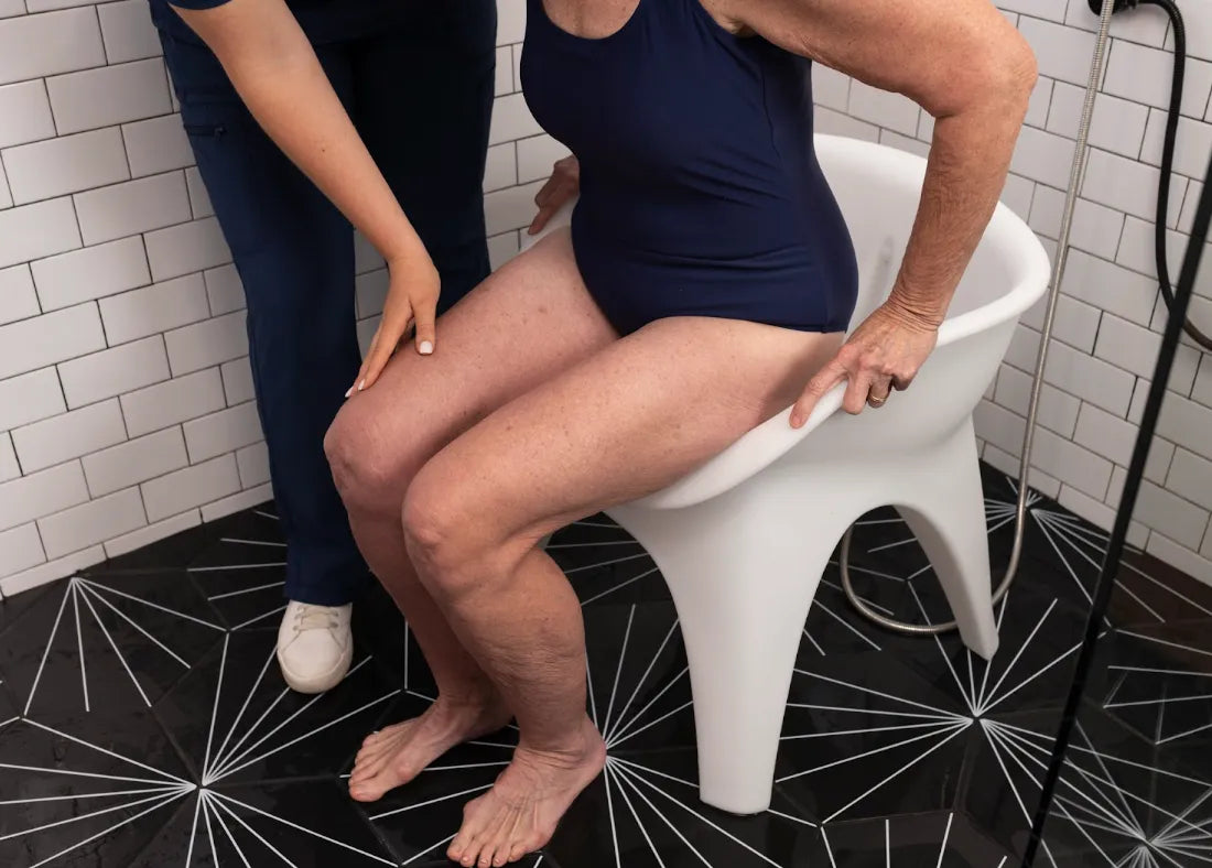 Caregiver helping a woman sit on SoSoak